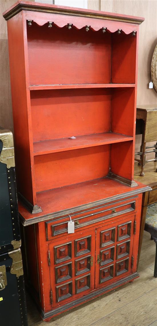 A red and black painted cupboard, fitted shelves over a drawer and a cupboard W.87cm